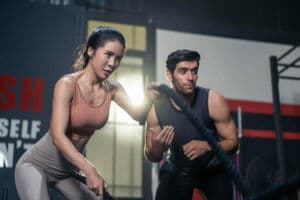 Fit woman working with male personal trainer