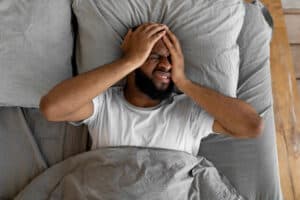 Man waking up hungover with a headache