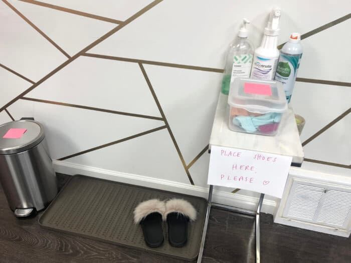 hand sanitizer station and shoes on a mat