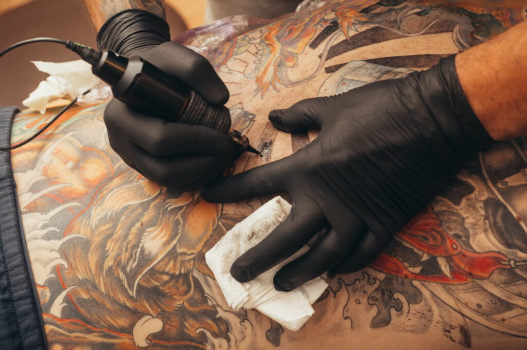tattoo artist giving full back tattoo