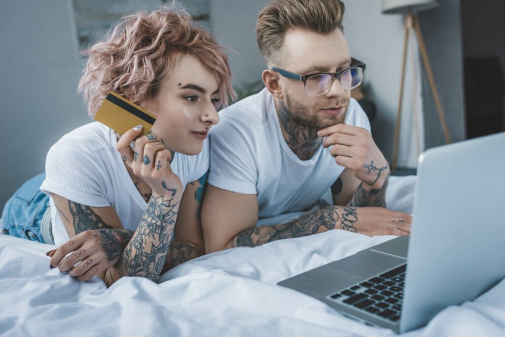 Tattooed couple paying for service online