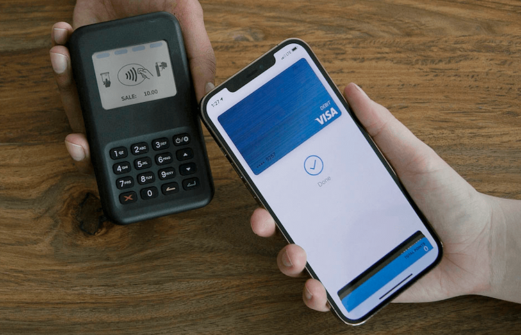person using apple pay on salon pos card reader