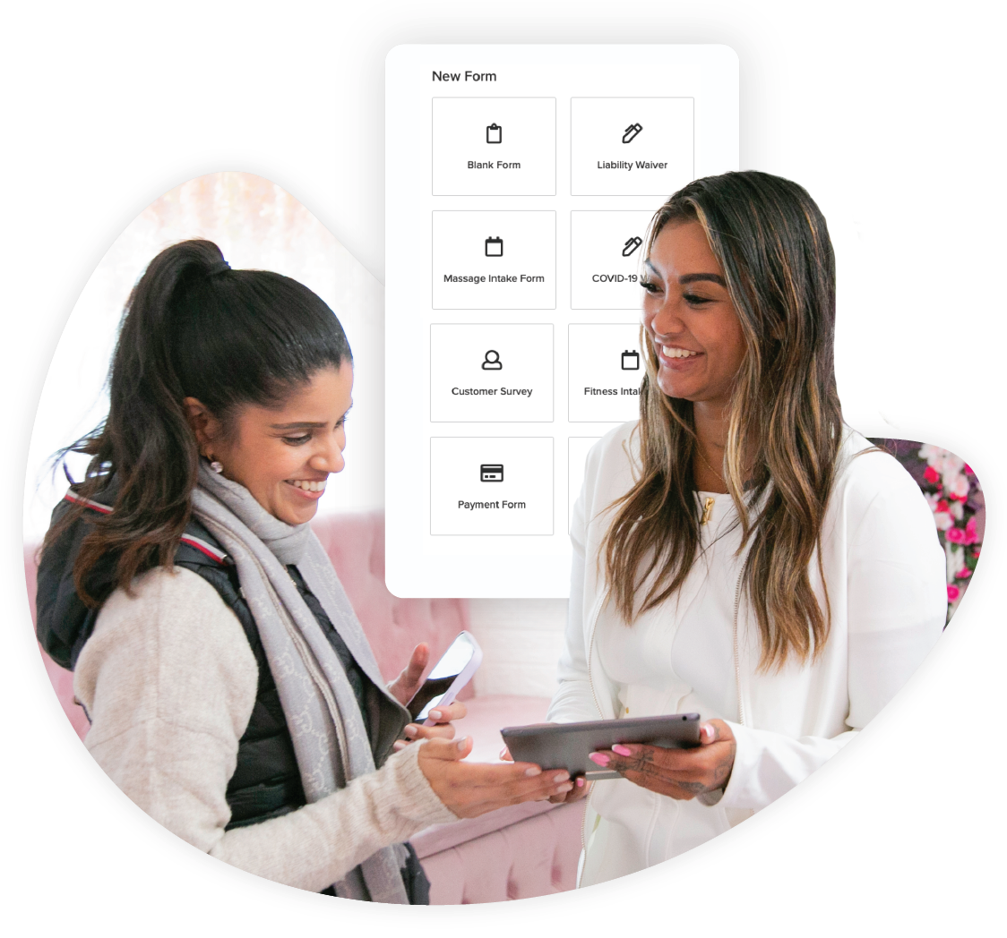 An image of a salon owner holding a tablet and showing a customer a consultation form with Vagaro's salon software.